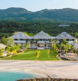 three roofed hotel with lawn and beach