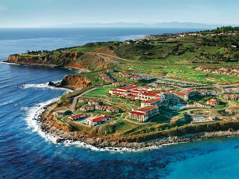 aerial view of resort located on a lush peninsula