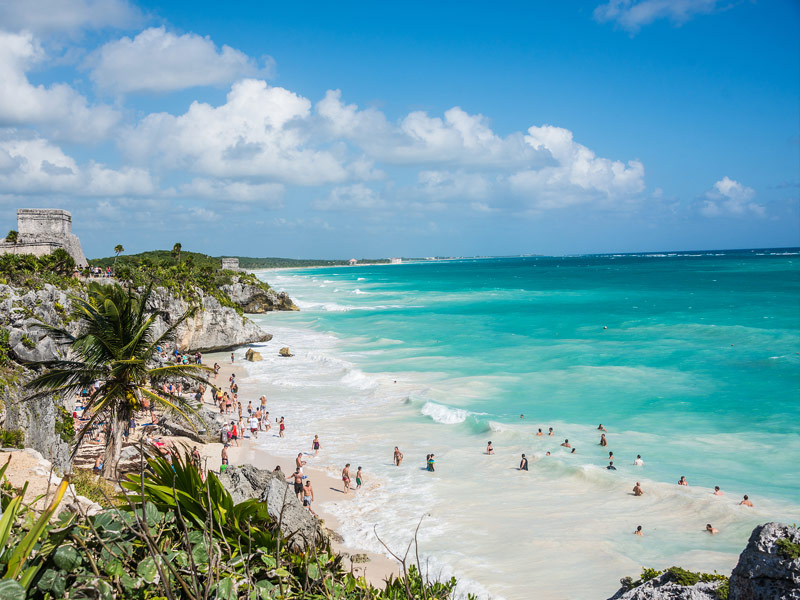 People swimming in shallows of turquoise water