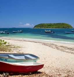 red boat on beach with water