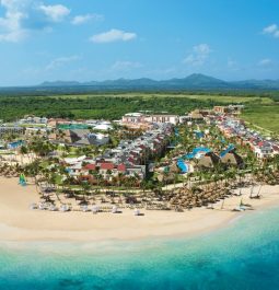 aerial view of beach with resort and mountains behind