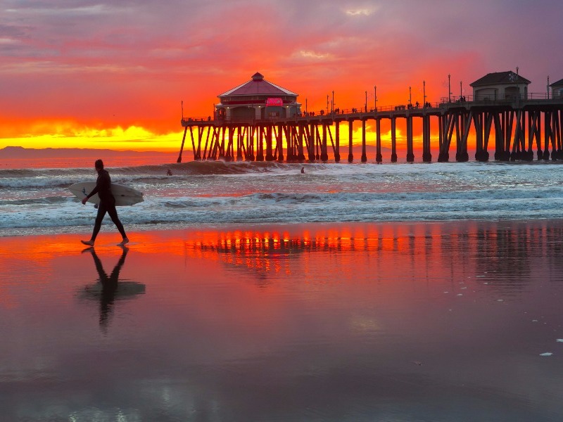 Surfer at sunset, Huntington State Beach, California