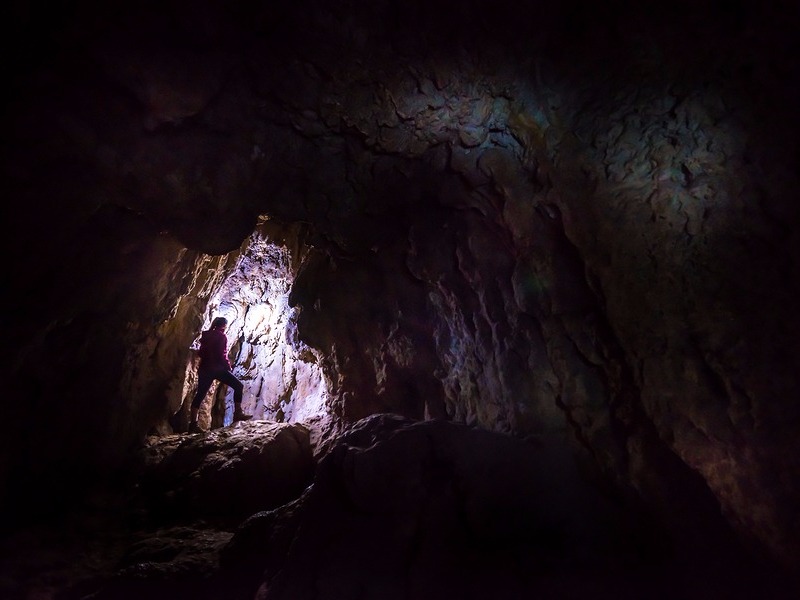 Woman Caver Spelunker exploring inside of a Dark Cave