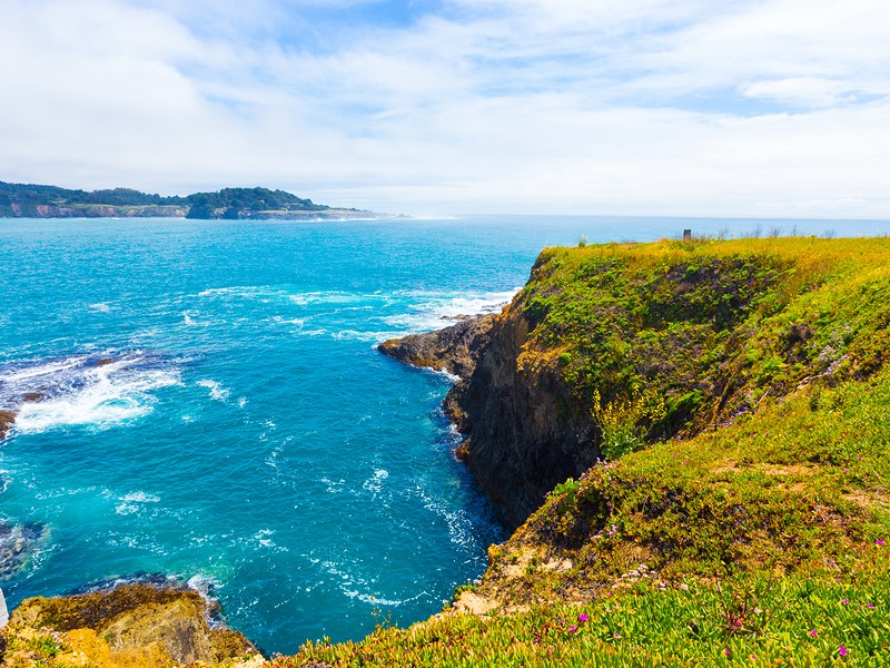 Beautiful rocky coastline and churning ocean below cliffs near Mendocino Bay on sunny day in California. 