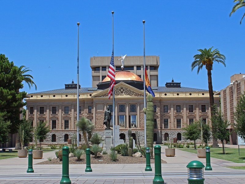 Front of Arizona State Capitol Museum and surrounding grounds against clear blue sky
