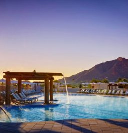 resort pool at sunset with fountain and mountain behind