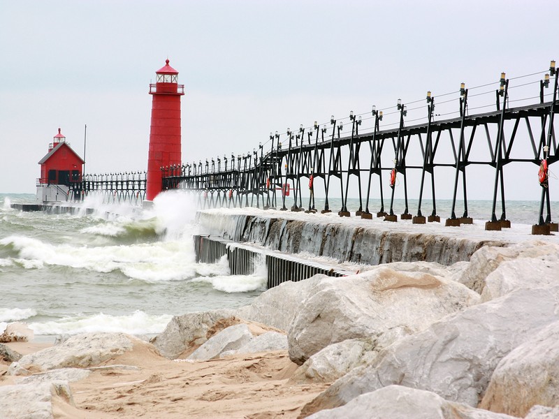 Beach rocks with a pier in the background in Grand Haven, MI