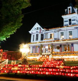 house with jack o lanterns lit up on sidewalk