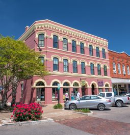 pink historic building in downtown area with flowers blooming