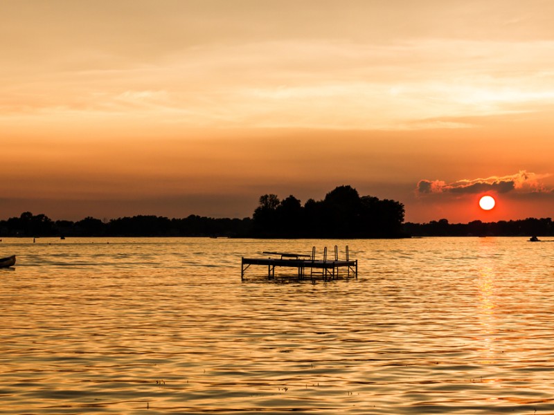 Deep sunset with warm oranges and blues over Dewart Lake near Syracuse, Indiana