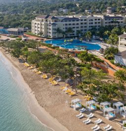 beachfront resort with swimming pool and lounge chairs on the beach