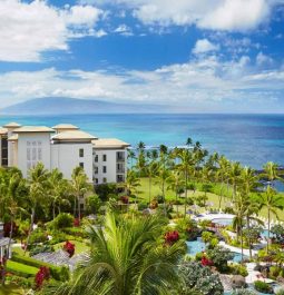 aerial view of oceanfront resort with volcano in the distance