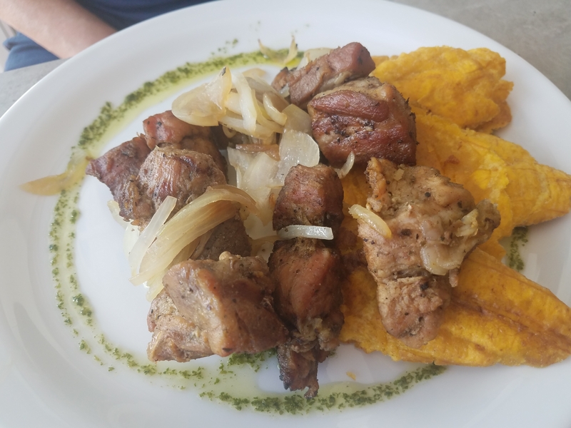 Fried pork with plantains on white plate