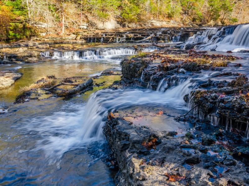 Clear water cascades over rock shelves at Burgess Falls State Park