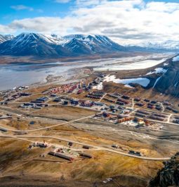 aerial view of norwegian town with snowcapped mountains and wide open space