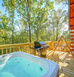 cabin deck with hot tub, swing, and grill