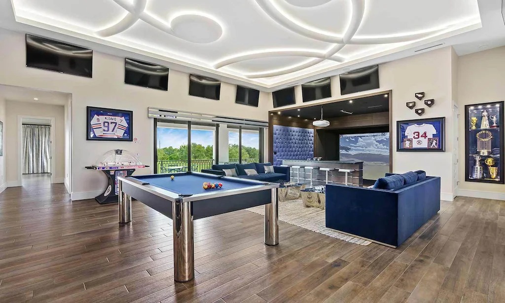 This sports-themed game room has its own golf simulator.