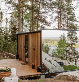 Mirrored walled cabin surrounded by tall pine trees