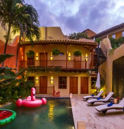 Evening time at villa with lights overlooking the pool with flamingo float