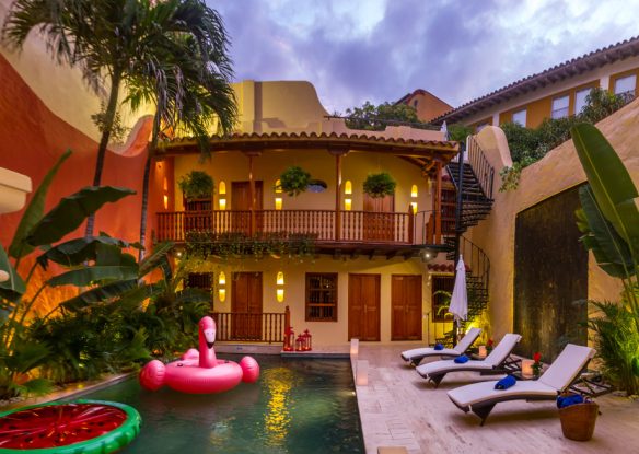 Evening time at villa with lights overlooking the pool with flamingo float