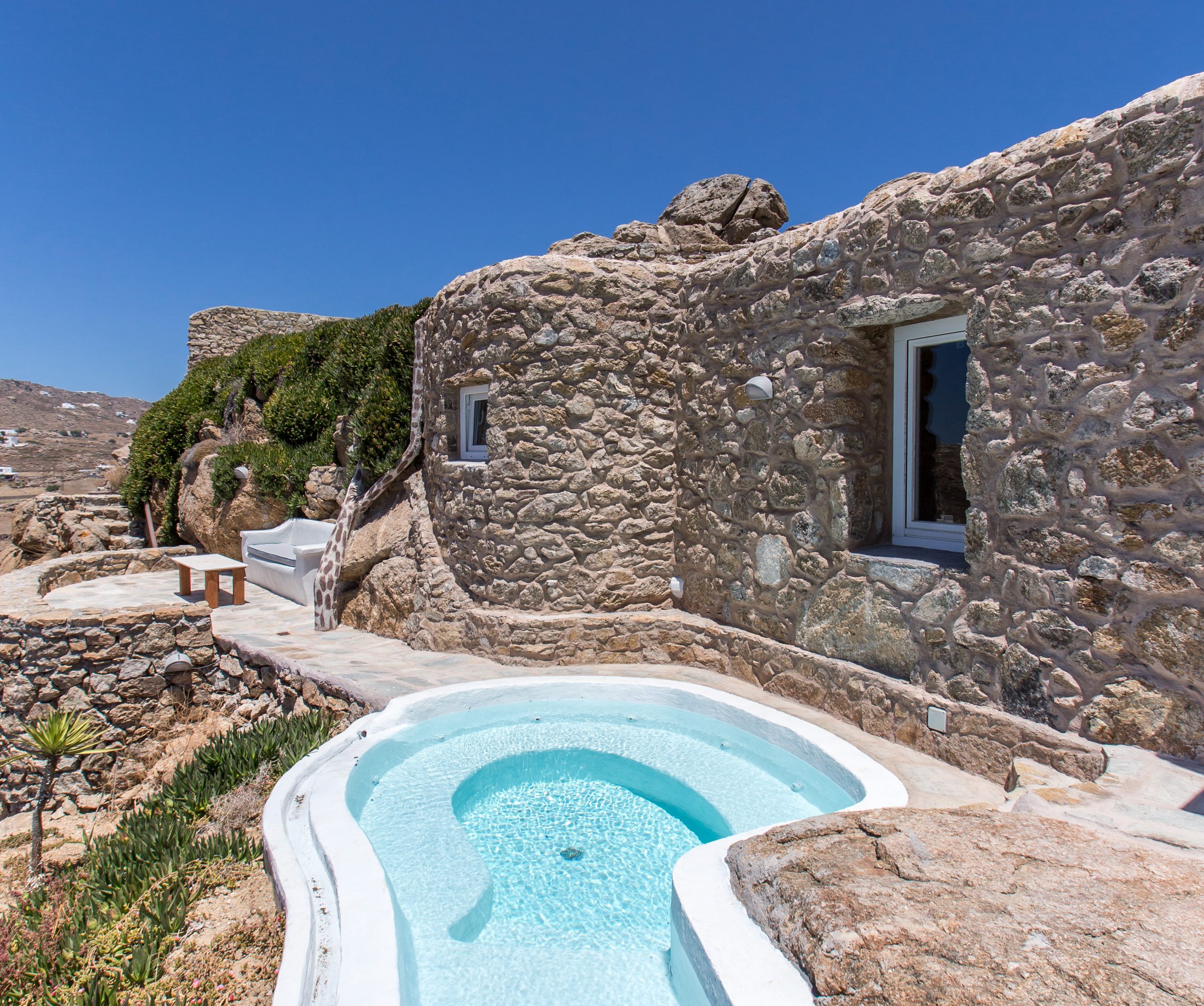 Cobblestone cave with white curved hot tub