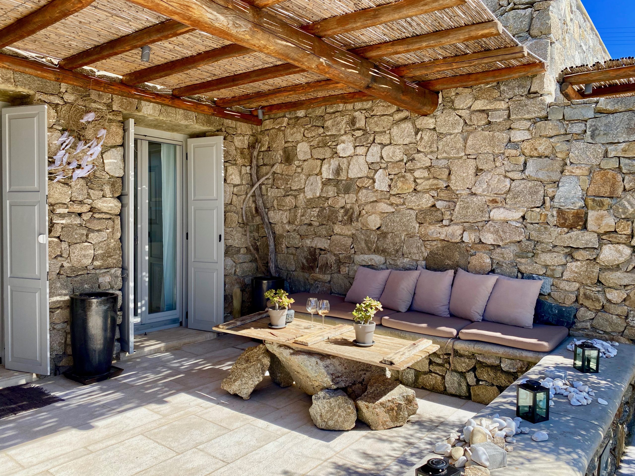 Semi outdoor living room with cobblestone walls and bright blue sky