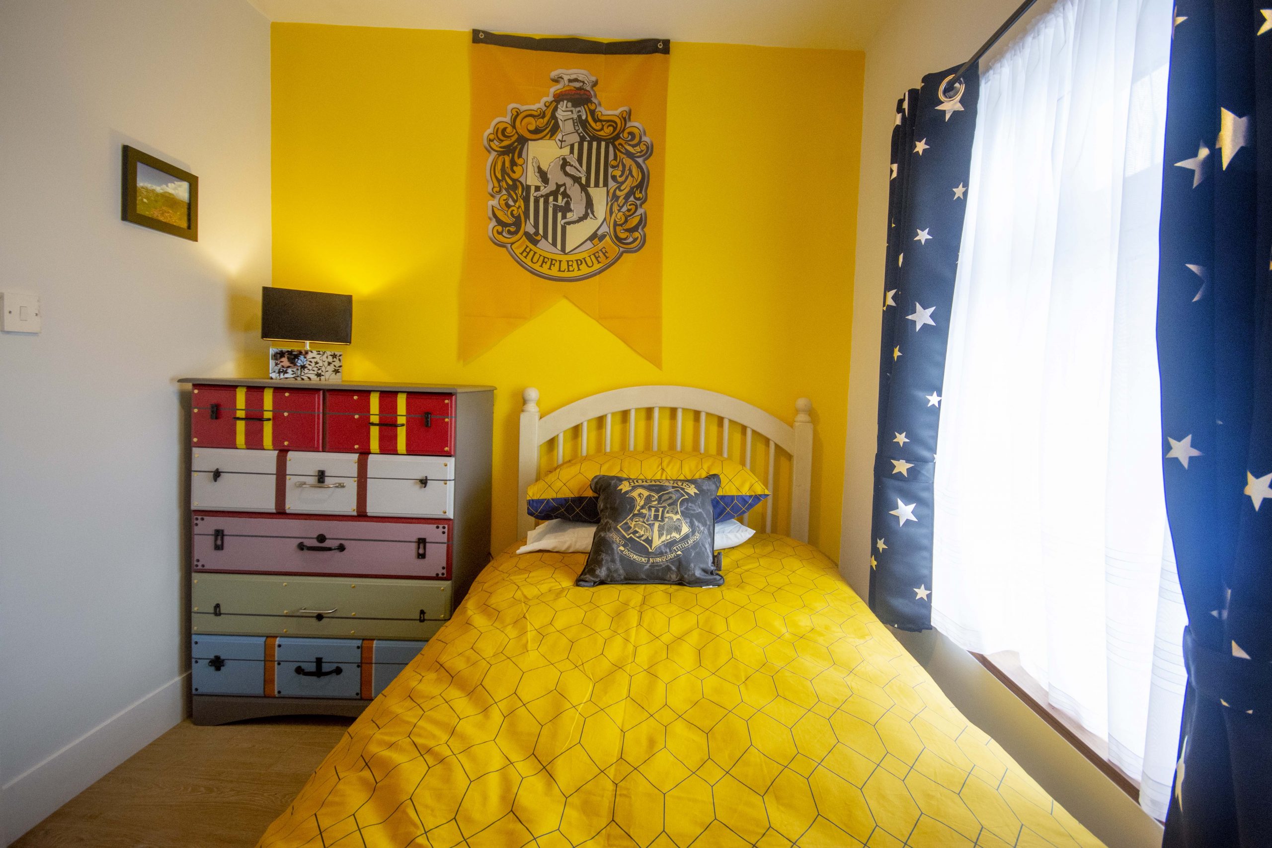 Yellow bedroom with themed curtains and wall hangings