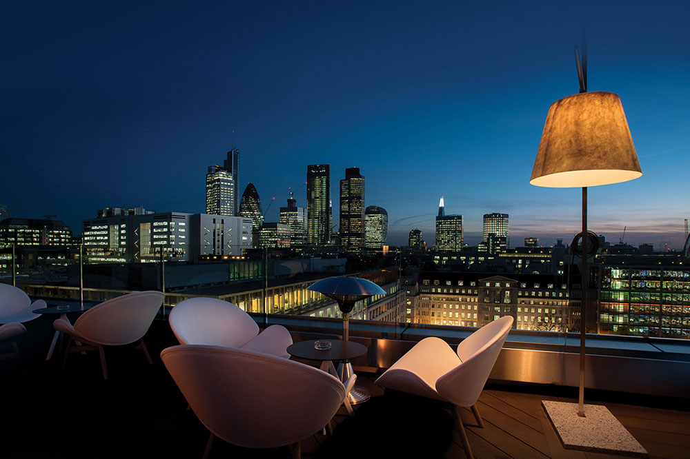 Roof terrace overlooking the city at night time