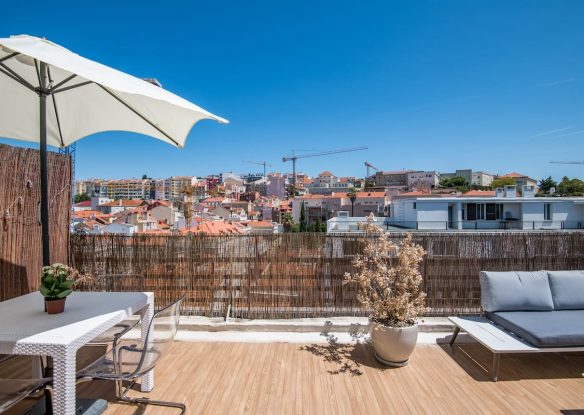 rooftop terrace with picnic table and umbrella