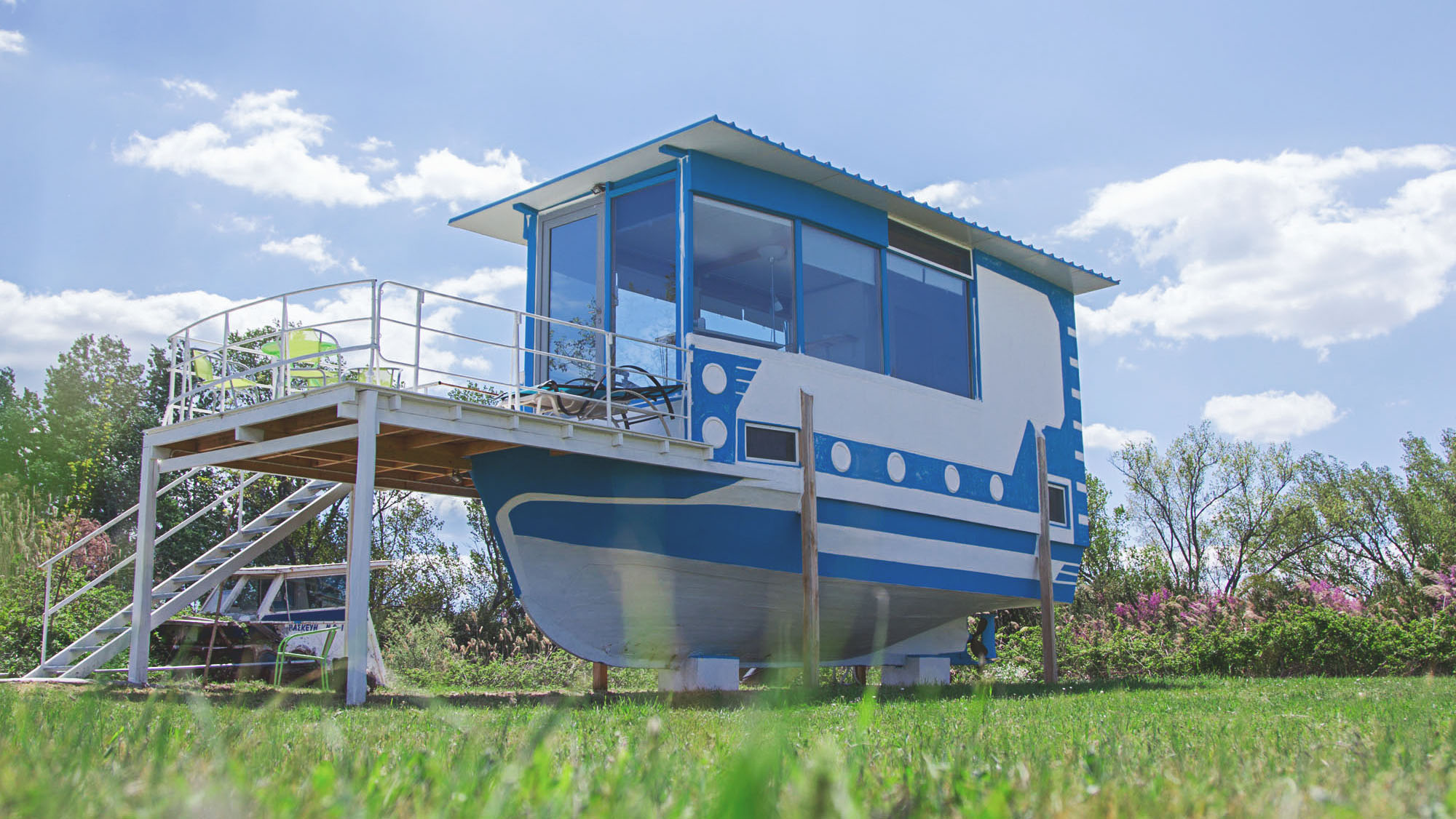 Blue and white boat sat on the grass