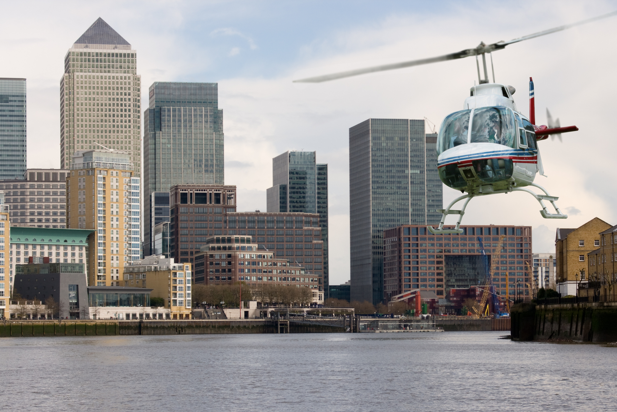 Helicopter flying along the Thames with Canary Wharf background