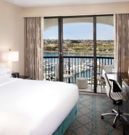 Hotel room with a white bed and a window view of the San Diego marina