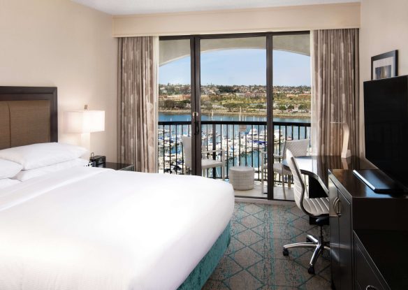 Hotel room with a white bed and a window view of the San Diego marina