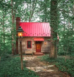 Cabin with red roof in woods