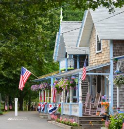 row of victorian-style cottages with gingerbread trim and front porch with american flag flying