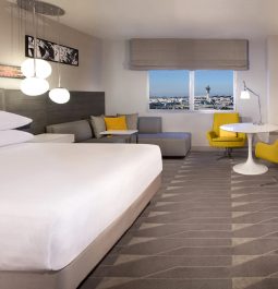 A modern hotel room with an airport window view