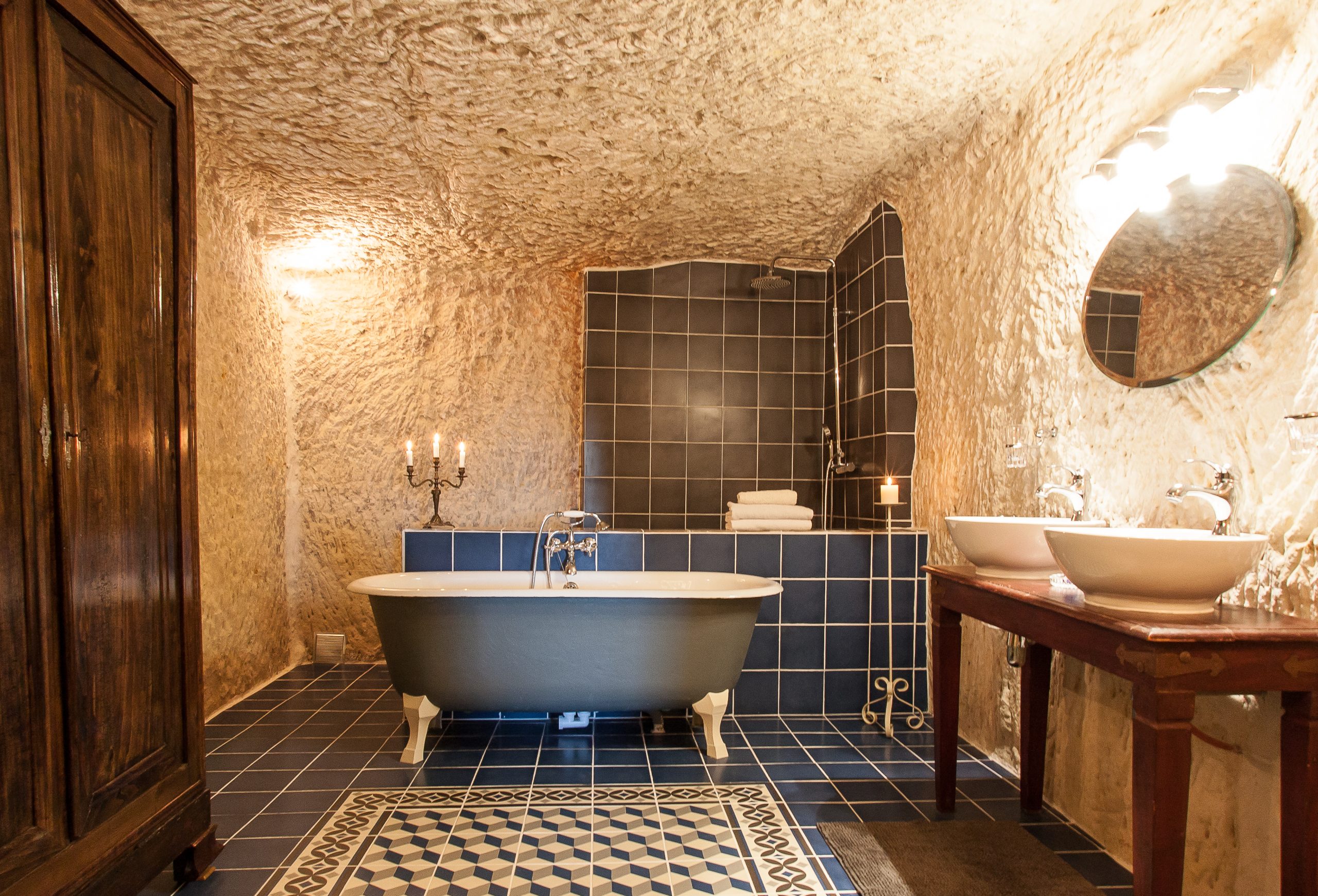 Cream-walled bathroom inside cave with claw foot bathtub