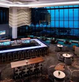 Big hotel lobby with panoramic windows overlooking a bay