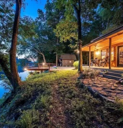 Cabin with lights on along the river