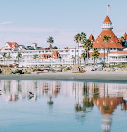 View from the water of a vast historic Victorian style resort painted white with terra cotta shingles