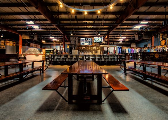 spacious brewery with long tables and wood tones