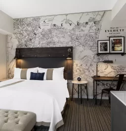 Hotel room with queen bed and map wallpaper