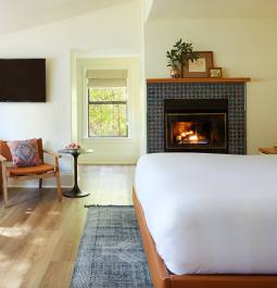 hotel suite with fireplace, bed, and couch