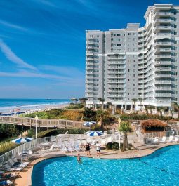 swimming pool by beachfront resort with pier from pool to beach