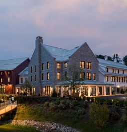 Exterior of a rustic hotel near the stream at dusk