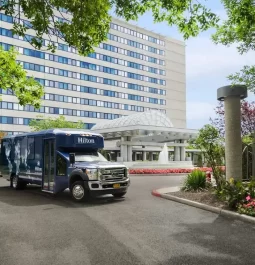 airport shuttle bus parked in front of a hotel