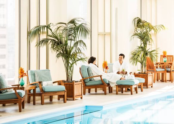 couple seated in robes at a luxury indoor pool