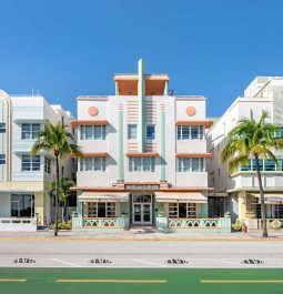 art deco hotel on a street full of art deco hotels and palm trees