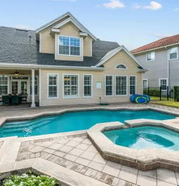 Swimming pool with a hot tub next to a mansion