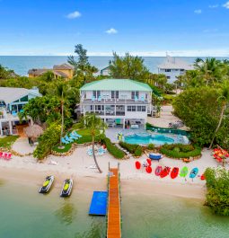 Aerial view of a three-storey house with a pool and a beach